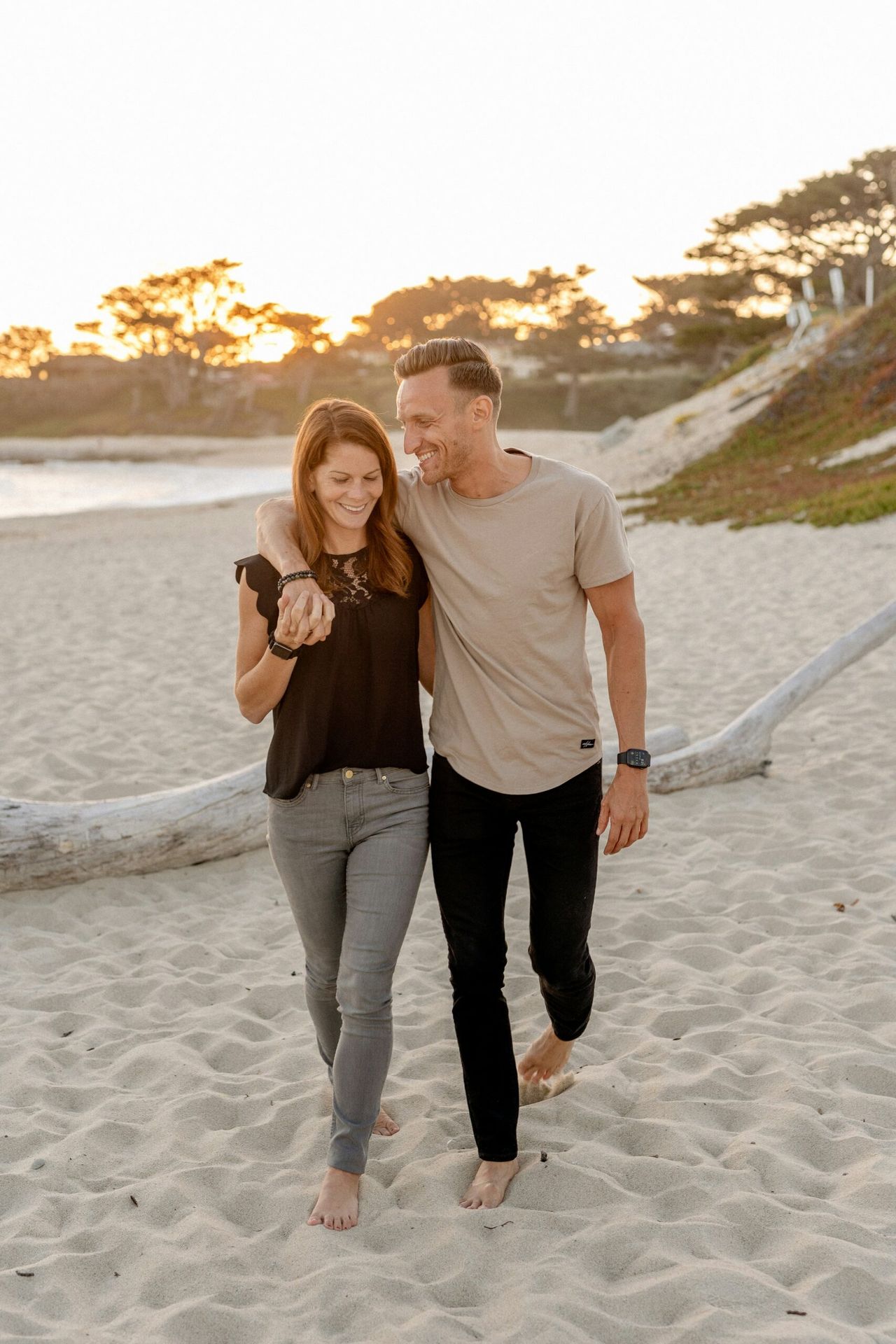 Couple walking arm in arm on a beach